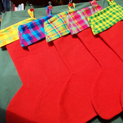 Five red Christmas stockings with different coloured cuffs