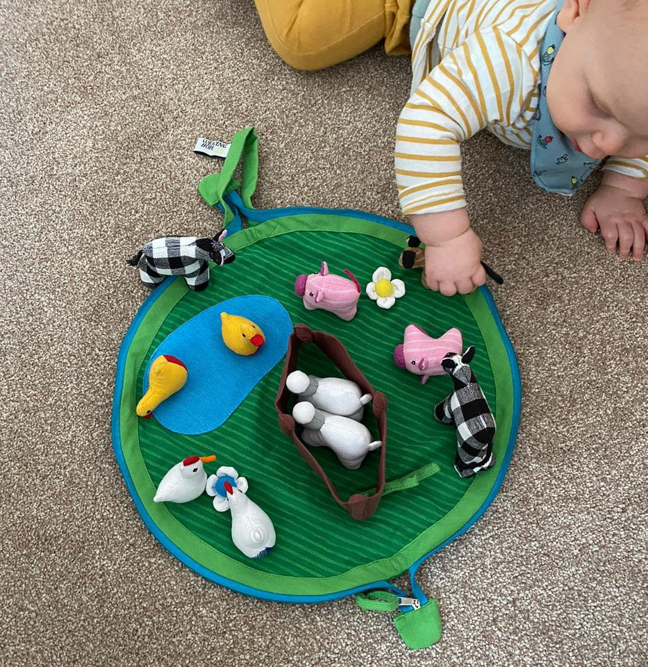 Young child playing with a fabric farm set