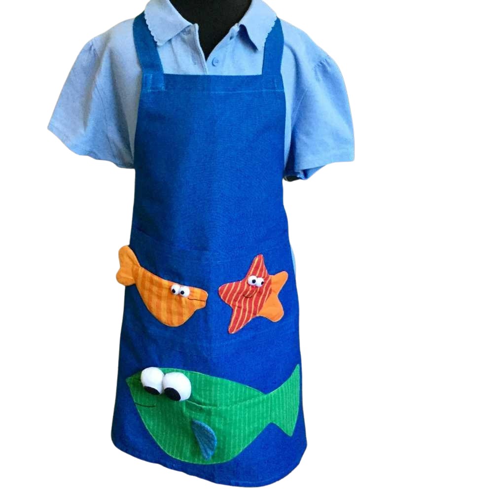 Child’s apron with green fish pattern on blue background