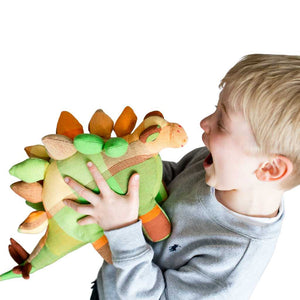 Child with multi-coloured stegosaurus cuddly toy